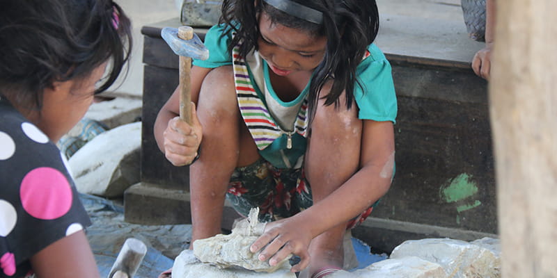 Kinderhände arbeiten mit Steinen