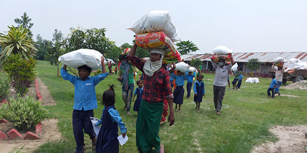 Katastrophenhilfe Menschen tragen Säcke mit Essen auf dem Kopf