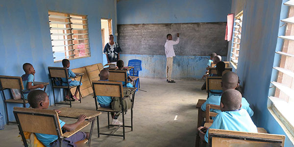 Kinder sitzen in der Schule und schauen nach vorne zum Lehrer
