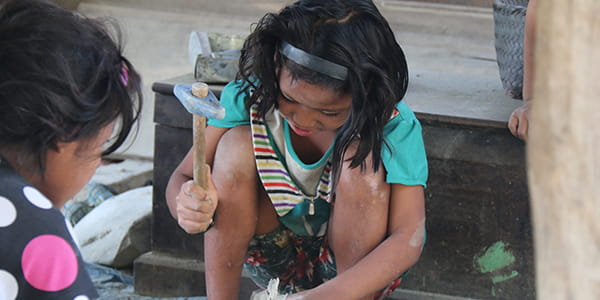 Kinderarbeit Kind schlägt mit Hammer auf Steine